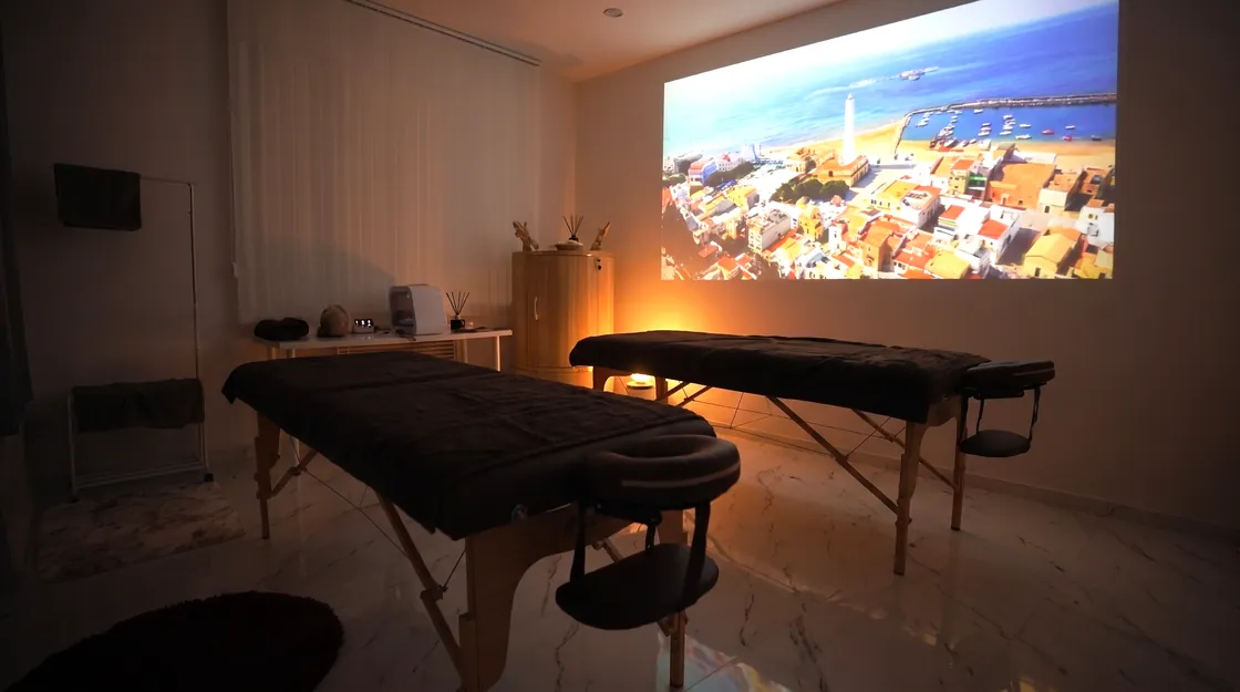 SPA-кабинет клиники вечером: два стола, свечи и проекция на стене